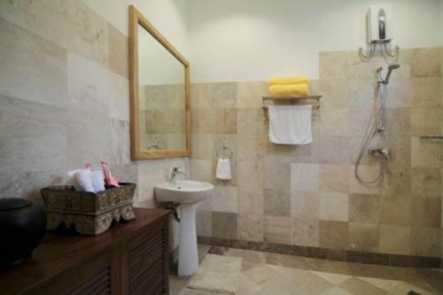 een badkamer met een wastafel, een toilet en een spiegel bij Sea Dream Resorts in Dauin