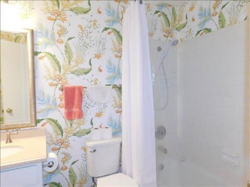 a bathroom with a toilet and a shower curtain at J15 lovely village area condo sleeps 6 comfy very nicely furnished screened in porch in Mallory Park
