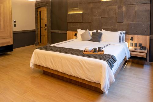 a bedroom with a large bed in a room at Hotel Patio Santiago in Querétaro