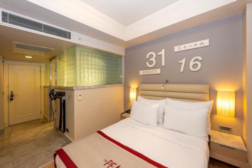 a bedroom with a bed and a clock on the wall at Ramada By Wyndham Istanbul Pera Taksim in Istanbul