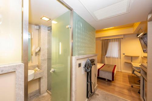 a room with a bathroom with a shower and a bed at Ramada By Wyndham Istanbul Pera Taksim in Istanbul