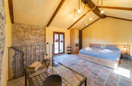 1 dormitorio con cama y pared de piedra en Porta Soprana, en Dogliani
