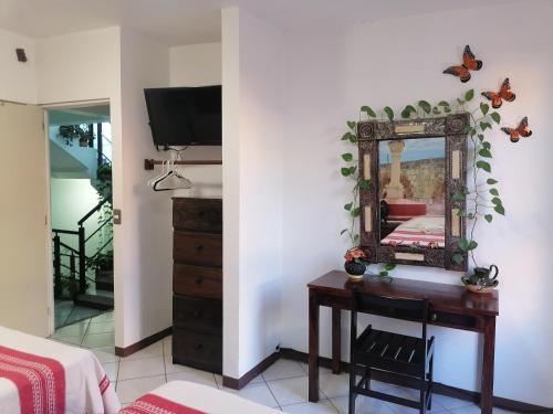 a bedroom with a mirror and a desk with a bed at Casa los Arcos Oaxaca in Oaxaca City