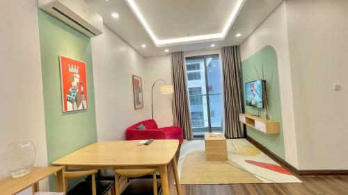 a living room with a table and a red chair at LAD Apartment & Homestay Hải Phòng - Hoàng Huy Grand Tower in Hai Phong
