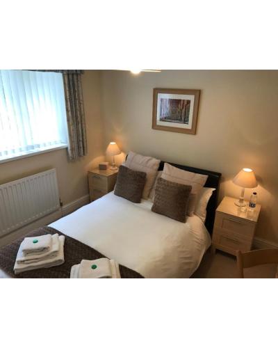 a bedroom with a white bed with two night stands at 31 Queens Road in Winchester
