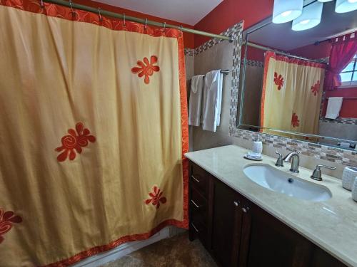 a bathroom with a sink and a shower curtain at Spicy Hill Villa in Port Antonio