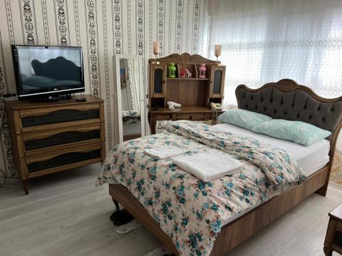 a bedroom with a bed and a tv on a dresser at SAYDAM OTEL in Seyhan