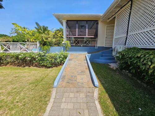 a house with a walkway in front of a yard at Spicy Hill Villa in Port Antonio