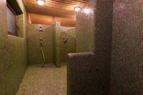 a bathroom with a shower with tiled walls at Hotel Planac in Corvara in Badia