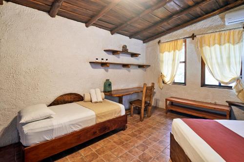 a bedroom with two beds and a desk in a room at Villa Havana in Mal País