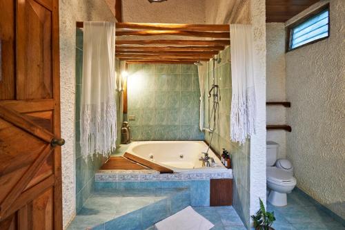 a bathroom with a bath tub and a toilet at Villa Havana in Mal País