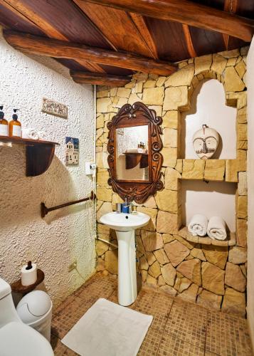 a stone bathroom with a sink and a mirror at Villa Havana in Mal País