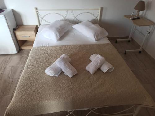 a bed with two white towels on top of it at Christos Family Apartments Β in Ágios Rókkos