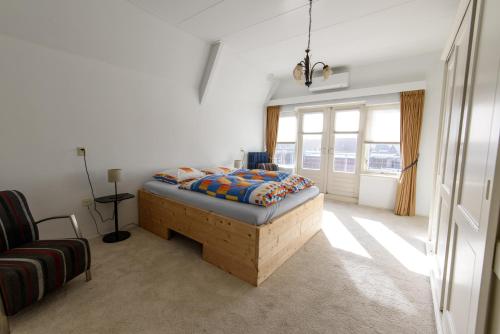 a bedroom with a bed and a couch and windows at City House Hoorn in Hoorn