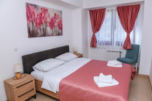 een slaapkamer met een groot bed en een blauwe stoel bij Flatiron Apartments Skopje in Skopje
