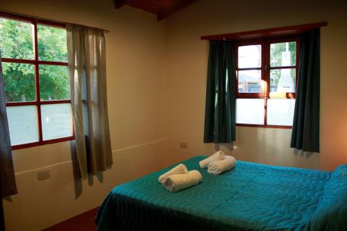 1 dormitorio con 1 cama con 2 toallas en Casanicca Habitaciones privadas en Casa Compartida en San Martín de los Andes
