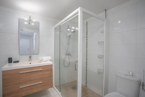 a bathroom with a shower and a toilet and a sink at Appartement standing vue sur mer des Caraïbes in Fort-de-France