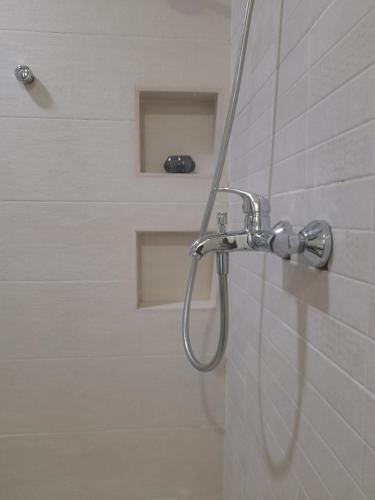 La salle de bains est pourvue d'une douche avec un pommeau de douche. dans l'établissement Beautiful Home - 2 Double Rooms, à Accra