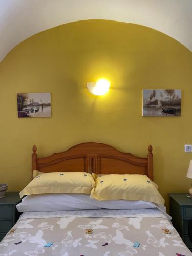 um quarto com uma cama com uma parede amarela em 2 bed cottage Lorca many hiking & cycling trails em Lorca