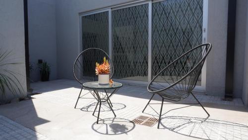 twee stoelen en een tafel met een kaars op een patio bij Casa Atilio -Dpto Premium con entrada autónoma in Rafaela