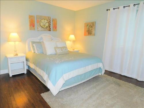 Un dormitorio con una cama y dos mesas y dos lámparas. en S3, comfy, close to pickleball, en Mallory Park