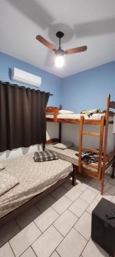 a room with three bunk beds and a ceiling fan at Hotel, Pousada e Restaurante Estrela Azul in Aparecida