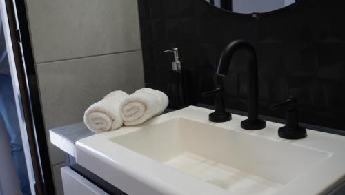 a bathroom with a sink with towels on it at Casa Atilio -Dpto Premium con entrada autónoma in Rafaela