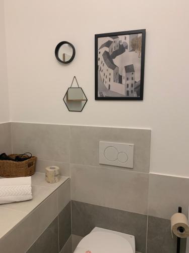 a bathroom with a toilet and a picture on the wall at Casimiro Home in Cesena