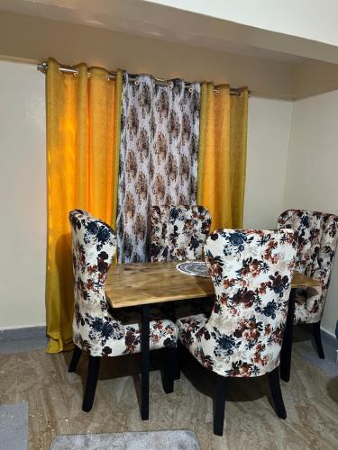a dining room with two chairs and a wooden table at Fully Furnished 2br Apartment King'ong'o Nyeri - Youngsky in Nyeri