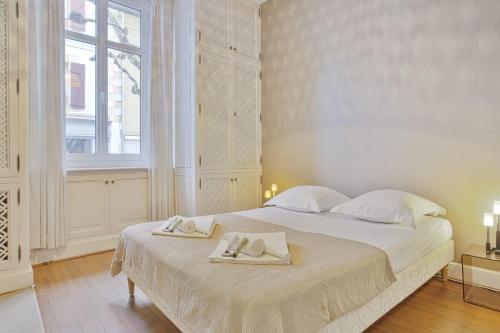biała sypialnia z łóżkiem z 2 ręcznikami w obiekcie Appartement Ampalia - Welkeys w Biarritz