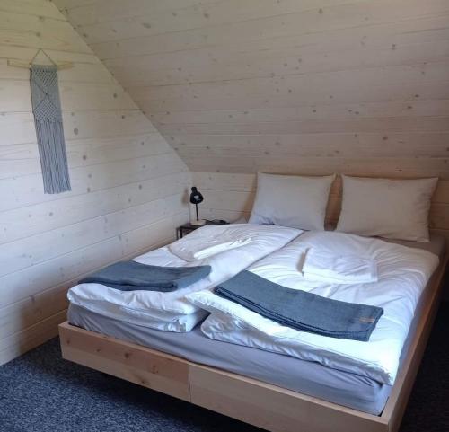 a bed in a wooden cabin with two pillows on it at Jasna Chata Kluszkowce in Kluszkowce