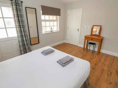 a bedroom with a white bed with two towels on it at North Beach at The Hideaway in Tenby