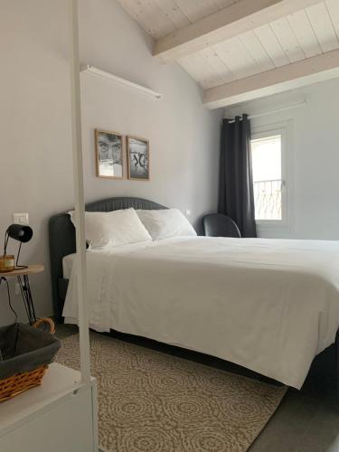 a bedroom with a large white bed and a window at Casimiro Home in Cesena