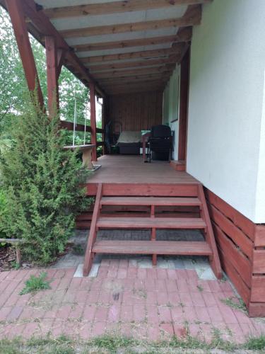 une terrasse couverte d'une maison avec une terrasse en bois dans l'établissement Agroturystyka u Wioli i Irka, domek u Elki , spływy kajakowe, à Karsin