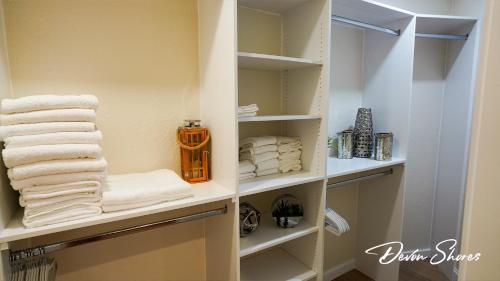 a walk in closet with white towels on shelves at Devon Shores in Clearwater Beach