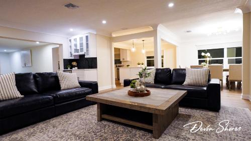a living room with black leather couches and a coffee table at Devon Shores in Clearwater Beach