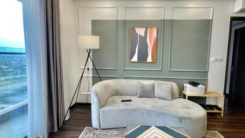 a living room with a chair and a lamp at LAD Apartment & Homestay Hải Phòng - Hoàng Huy Grand Tower in Hai Phong