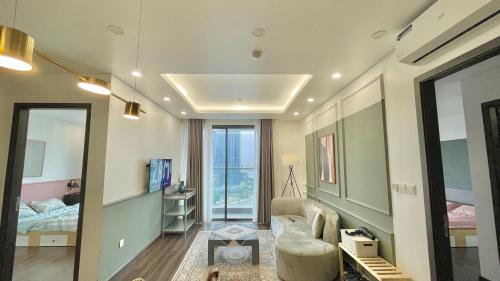 a room with a couch and a bed and a mirror at LAD Apartment & Homestay Hải Phòng - Hoàng Huy Grand Tower in Hai Phong