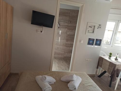 a bathroom with two towels on a bed and a shower at Christos Family Apartments Β in Ágios Rókkos