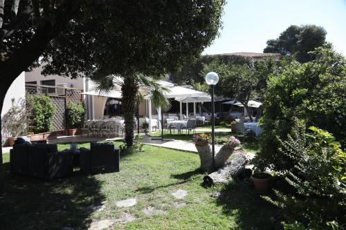 a yard with chairs and umbrellas in a building at HOTEL VULCI in Montalto di Castro