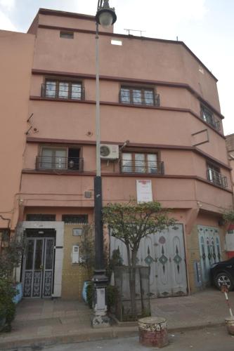 a pink building with a street light in front of it at Dar Benyounes in Benguerir