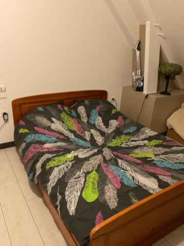 1 dormitorio con 1 cama con una manta colorida en CHAMBRES 24h DU MANS OU LE MANS CLASSIC OU GP MOTO, en Saint-Gervais en-Belin