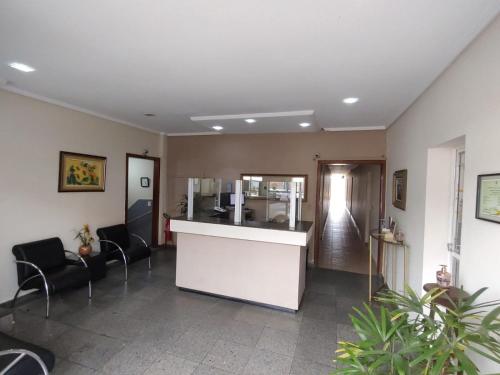 a lobby with a counter and chairs in a room at Hotel Mirante da Serra in Ouro Branco