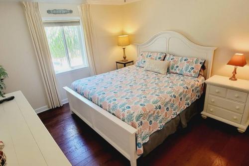 a bedroom with a bed with a white bedspread and a window at c2 Ocean Walk Pool view village area cozy Upstairs sleeps 5 1 king bed two sleepers in Mallory Park