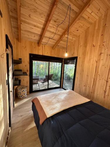 a bedroom with a large bed in a wooden room at Cabaña Chucao, Nativo Lodge in Curacautín