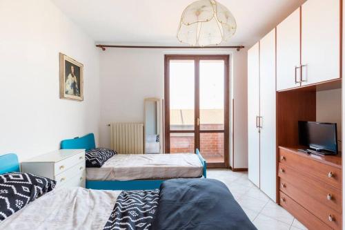 a bedroom with two beds and a dresser and a tv at Piacevole Appartamento Arzago in Arzago d'Adda