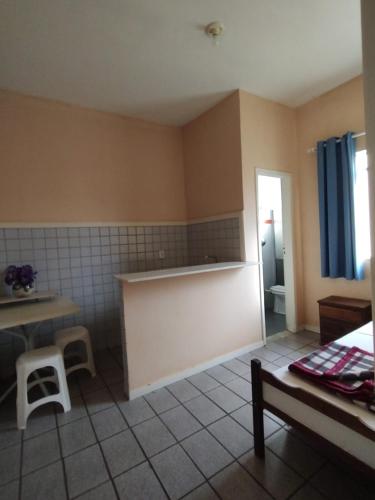 a room with a kitchen with a counter and a table at Hotel Mirante da Serra in Ouro Branco