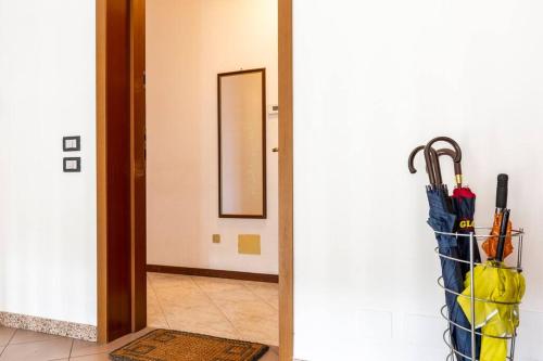 a hallway with an open door with umbrellas at Piacevole Appartamento Arzago in Arzago d'Adda