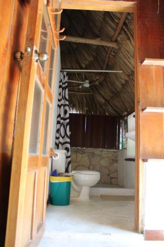 eine offene Tür zu einem Bad mit WC in der Unterkunft Posada del Cerro in El Remate