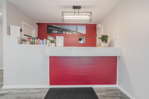 a red garage door with a red wall at Motel Champlain in Brossard